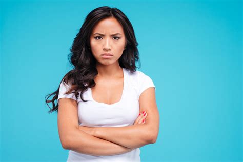 Angry Pretty Asian Woman Standing With Arms Crossed Isolated On The Blue Background Royalty Free