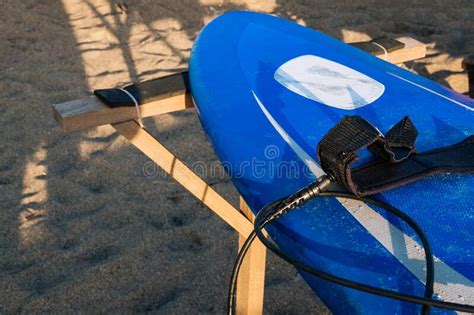 Blue And White Surfboard Lying On A Board Rack Ready For Surfing Close
