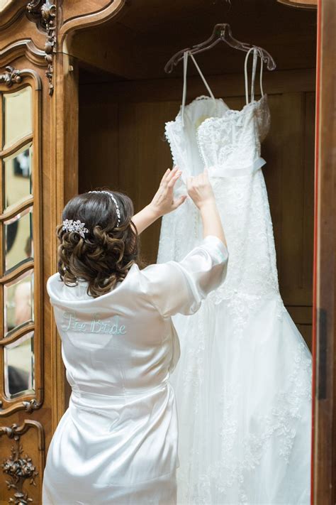 Bride Before The Ceremony Looking At Her Dress In White Bride Silk Robe