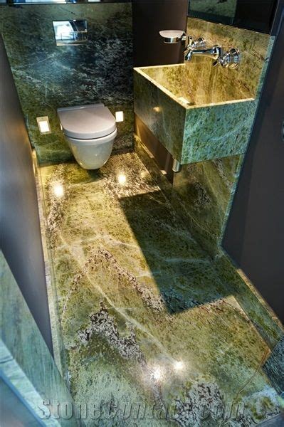 A Bathroom With Green Marble Counter Tops And A White Toilet In The