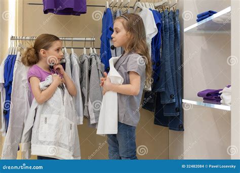 Two Little Girls Try On Clothes In A Modern Store Stock Images Image