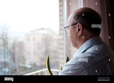 Elderly Caucasian Man Looking Out Window With Lonely Expression Stock