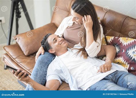Young Couple Enjoy Time At Home Watching Tv On The Sofa Happy Girl