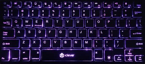An Illuminated Keyboard Is Shown In The Dark With Purple Lighting On It