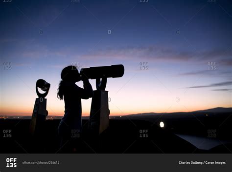 Silhouette Of Girl Looking Through Telescope At Dusk Stock Photo Offset