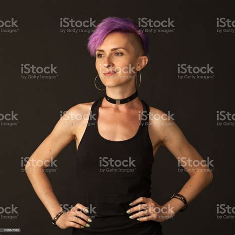 Studio Portrait Of A 30 Year Old Woman With Purple Iroquois On A Black