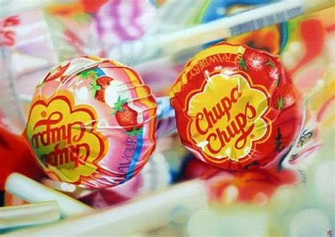 Two Lollipops Sitting On Top Of Each Other In Front Of Some Candy