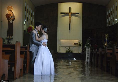 love conquers all filipino newlyweds share a kiss while knee deep in floodwaters as the