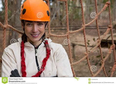 Portrait Of Smiling Woman Posing Near A Rope Fence In The Forest Stock
