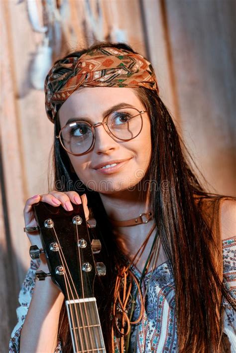 Beautiful Hippie Girl In Headband And Glasses Sitting With A Guitar