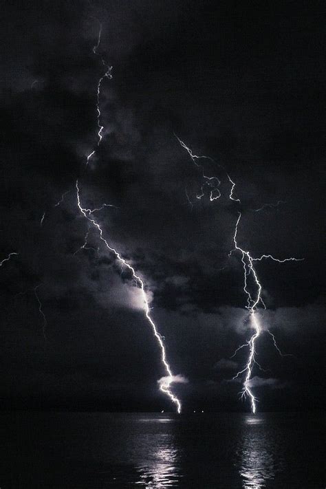 Black And White Photograph Of Lightning Striking Over The Ocean
