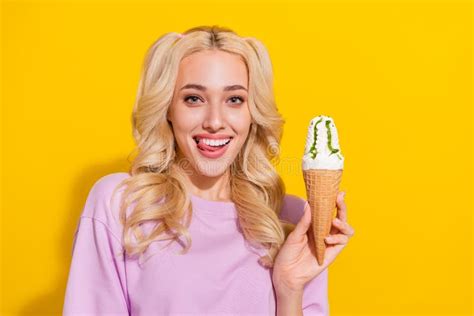 Portrait Of Cheerful Cute Girl Tongue Lick Teeth Hold Ice Cream Look Camera Isolated On Yellow