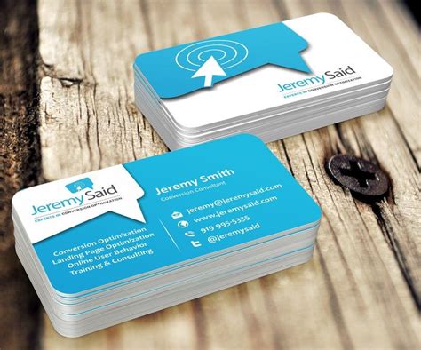 Two Business Cards Sitting Next To Each Other On Top Of A Piece Of