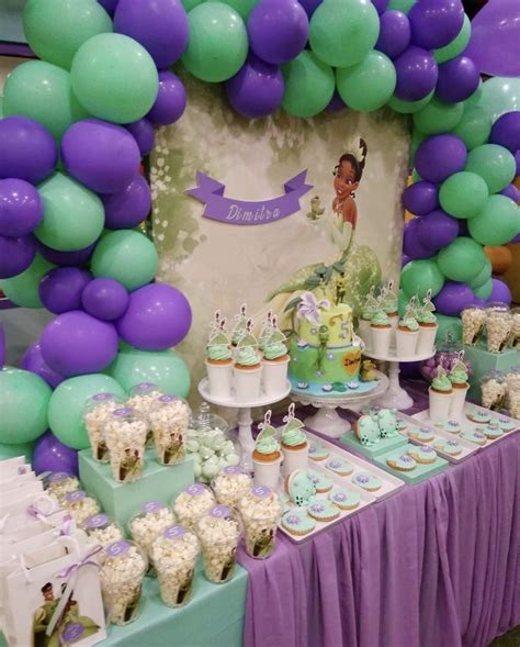 A Table Topped With Lots Of Cake And Cupcakes Next To A Purple And