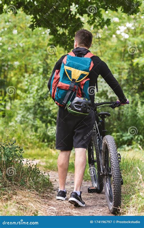 Back View Of Guy Backpacking With Bike In Forest Stock Image Image Of