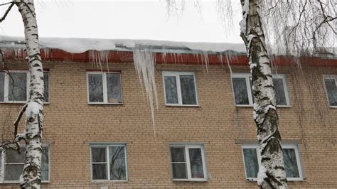Premium Photo Big Icicles On The Roof Of A Townhouse On A Snowy
