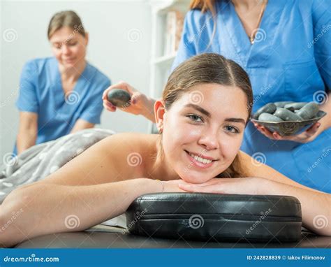 smiling girl getting professional stone massage from two masseuse stock image image of