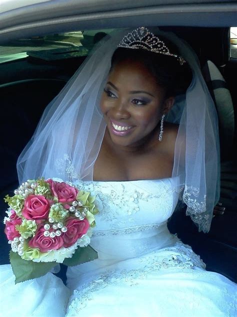 A Bride Sitting In The Back Seat Of A Car With Her Bouquet And Tiara