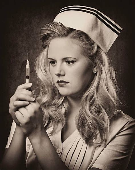 Portrait Of A Young Retro Nurse Looking At A Needle As She Prepares