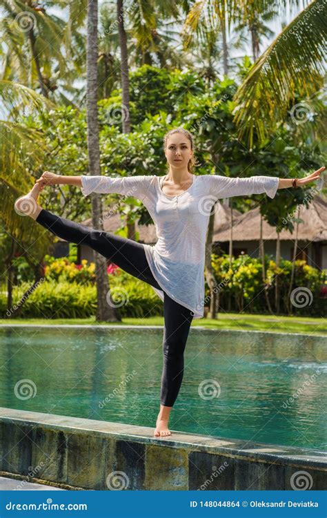 Beautiful Woman Makes Yoga Practice Meditation Stretching Leg In Standing Pose On The Edge Of