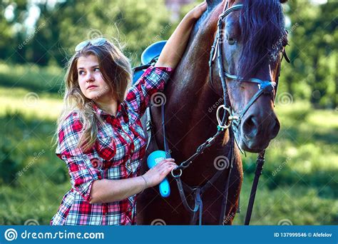 Beautiful Girl With Long Hair On A Walk With A Horse Stock Photo