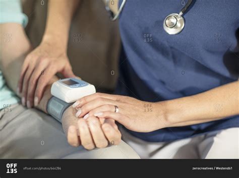 Nurse Taking Blood Pressure Of Senior Patient At Home Stock Photo Offset