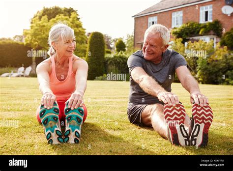 Healthy Senior Couple Exercising In Garden Together Stock Photo Alamy