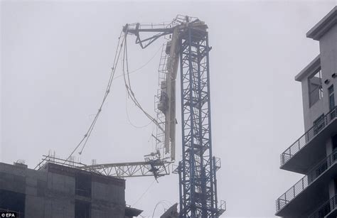 Partial building collapse near miami. Large crane atop Downtown Miami high-rise collapses