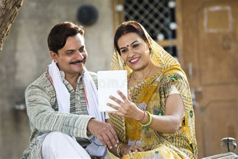 Rural Indian Wife And Husband Using Digital Tablet At Village Stock