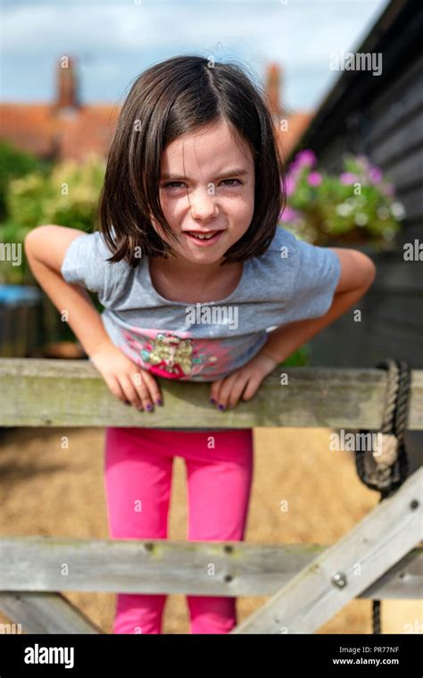 6 Year Old Girl Standing On Back Garden Gate Hi Res Stock Photography