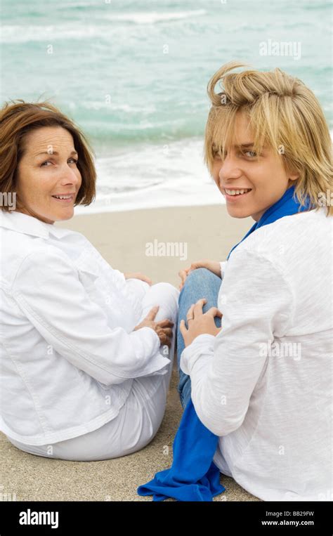 Teenage Boy Sitting With His Grandmother On The Beach Stock Photo Alamy