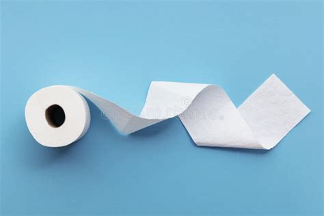 A Single Roll Of Toilet Paper Unrolled On A Blue Background Stock Image