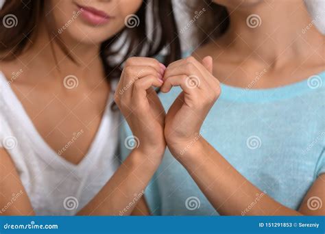 lyckliga unga lesbiska par som gör hjärta med deras händer closeup fotografering för bildbyråer