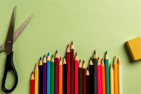Colored Pencils Scissors And Eraser Lie On Colored Paper Stock Photo