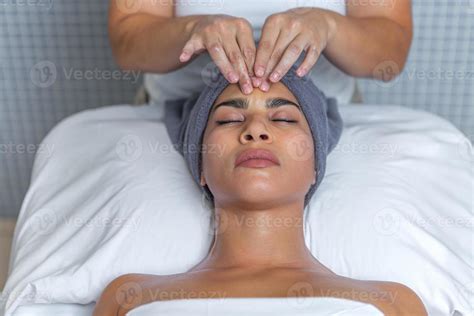 Esthetician Giving A Facial Massage With Cream On A Relaxed Womans Face At Health Spa 19986972