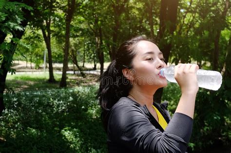 Asian Young Woman In Sportwear Thirsty And Drinking Water In Bottle