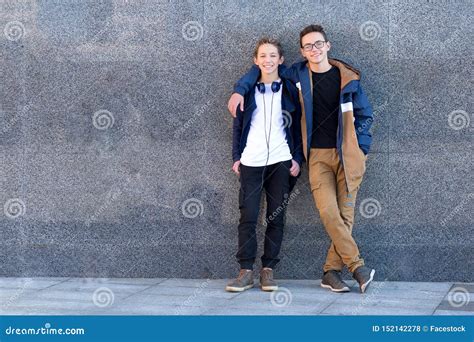 Two Happy Male Friends Standing Together And Looking At Camera Stock