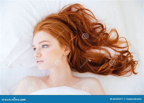 Attractive Woman With Beautiful Long Red Hair Lying In Bed Stock Image