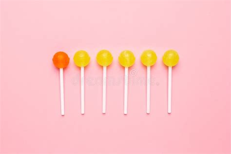 Sweet Yellow And Orange Candy Lolipop On Pastel Pink Background