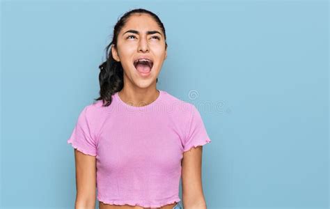Hispanic Teenager Girl With Dental Braces Wearing Casual Clothes Angry And Mad Screaming
