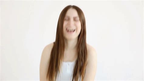 Beautiful Happy Girl Laughing Cheerfully By The White Wall Stock Video