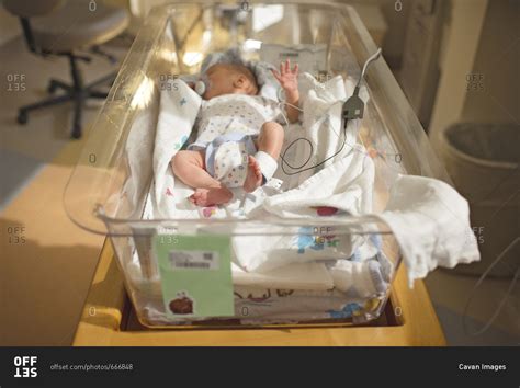 High Angle View Of Newborn Baby Boy Sleeping In Crib At Hospital Stock