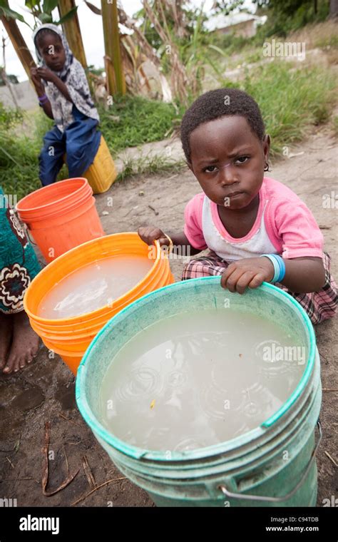 A Child Sits With Dirty Water At A Well Outside Dar Es Salaam Tanzania