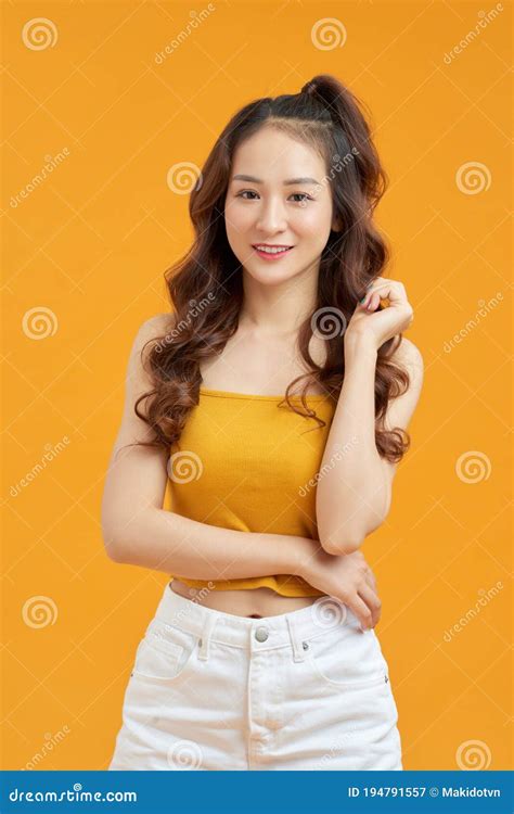 Joyful Young Asian Woman In Yellow Crop Top Posing Isolated On Yellow Background Stock Image