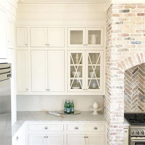Cozy kitchen with brick backsplash and wooden furniture throughout. Kitchen cabinet paint color is "White Dove Benjamin Moore ...