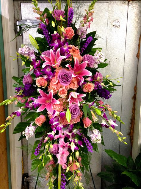 funeral standing spray with pinks and violets focal flowers being pink roses and stargazer