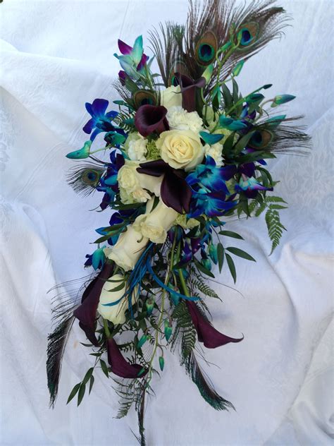 Blue and cream cascading wedding bouquets. #PeacockWedding Cream roses, burgundy callas, blue ...