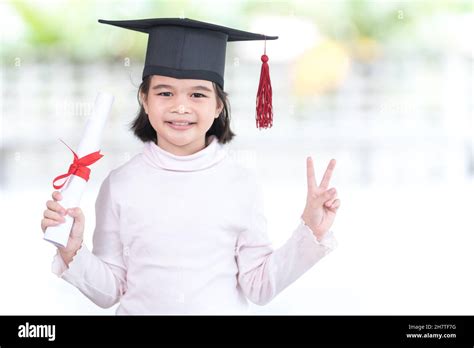 Happy Southeast Asian Schoolgirl With A Certificate Celebrating Graduation In Thailand Stock