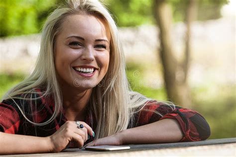 Smiling Happy Blond Woman Sitting At An Outdoor Table Stock Image