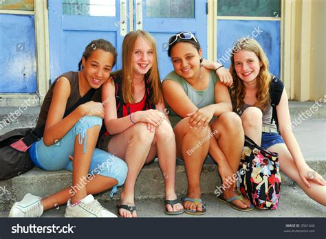 Portrait Of A Group Of Young Smiling School Girls Sitting On Steps Near